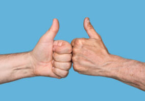 Two hands giving thumbs up to each other.