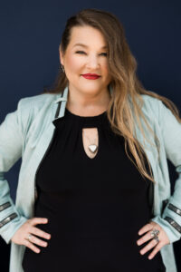 A woman with long hair and wearing purple shirt.